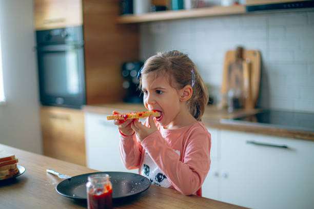 istock Little girl is having breakfast in the kitchen 2188485228