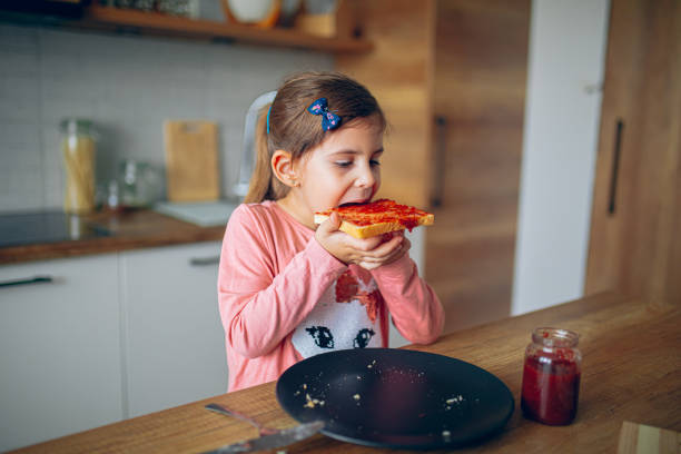 istock Little girl is having breakfast in the kitchen 2188485248