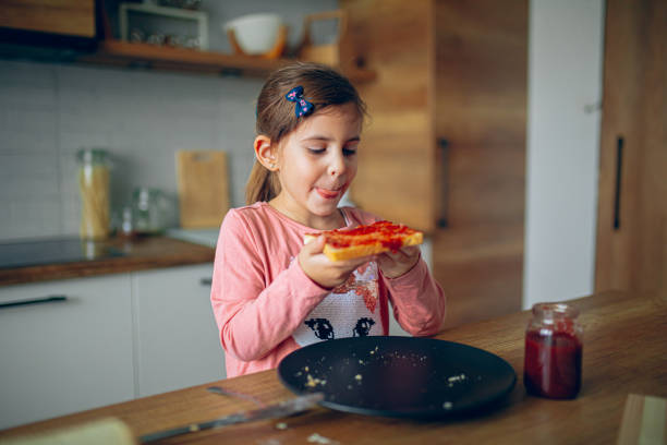 istock Little girl is having breakfast in the kitchen 2188485916
