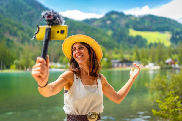 Influencer creating content at lake dobbiaco, dolomites, italy