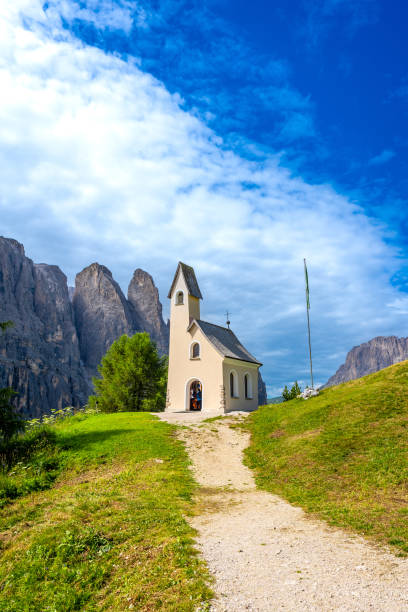 Small church at passo gardena with the dolomites in the background during a sunny summer day