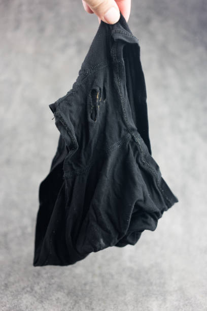 istock Man hand holds old and torn underwear pants from long time wearing. 2188488963
