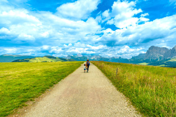 istock Tourists walking on path at alpe di siusi in dolomites, italy 2188489225