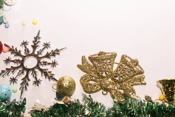 Season's greetings scene. Christmas decorations, gift boxes with red ribbons, сhristmas balls,  rustic star, holly berries, frosty spruce branches, confetti on white backdrop, selective focus with blur