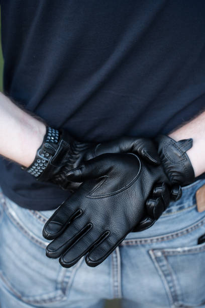istock A man stands with his back wearing black leather brutal gloves 2188492837
