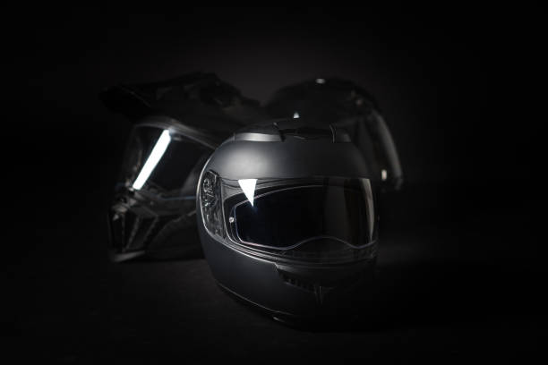 Black motorcycle helmet on a black background.