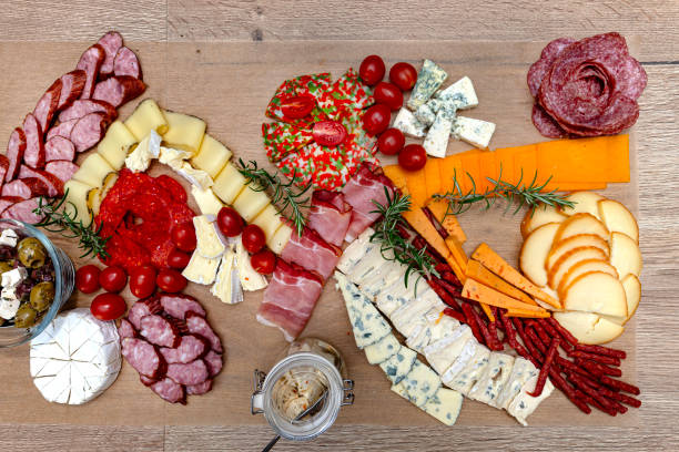 istock Various cheeses and cold cuts spread out on the table on baking paper, evening party at home, top view. 2188494984