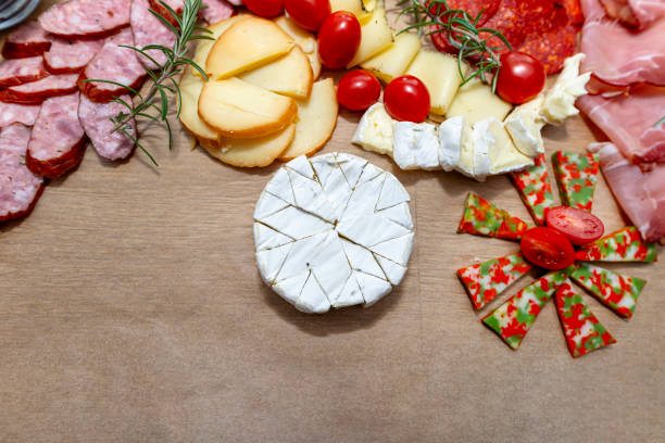 istock Various cheeses and cold cuts spread out on the table on baking paper, evening party at home, top view. 2188495225