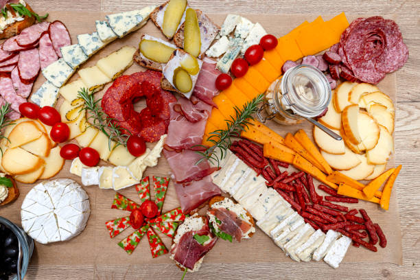 istock Various cheeses and cold cuts spread out on the table on baking paper, evening party at home, top view. 2188495226