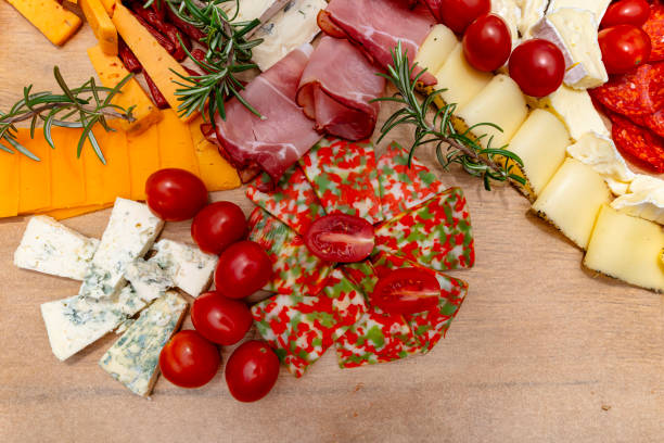 istock Various cheeses and cold cuts spread out on the table on baking paper, evening party at home, top view. 2188495227