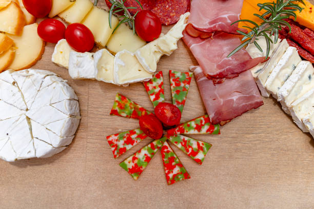 istock Various cheeses and cold cuts spread out on the table on baking paper, evening party at home, top view. 2188495228
