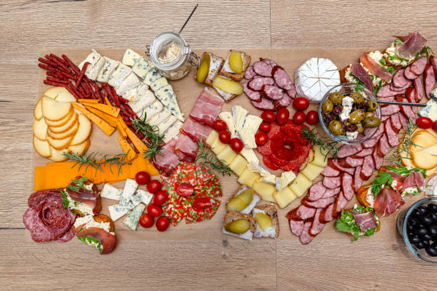 istock Various cheeses and cold cuts spread out on the table on baking paper, evening party at home, top view. 2188495403