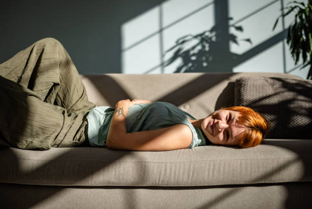 istock Joyful person lounging on sofa in sunlit room. 2188496686