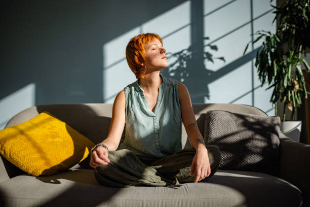 istock Relaxed woman meditates with sunlight in cozy room. 2188498184