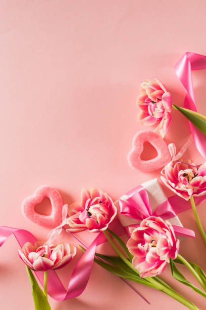 istock Pink tulips and hearts, gift box with ribbon on light pink background 2188498596