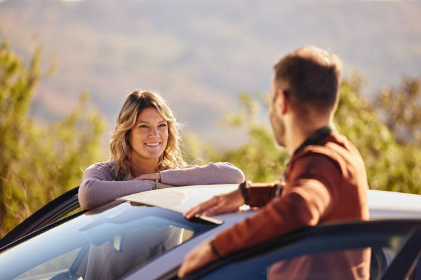 istock Happy couple talking before a trip by a car in autumn day. 2188502428