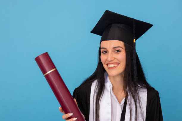 istock Confident young woman in graduation robe and cap 2188503148