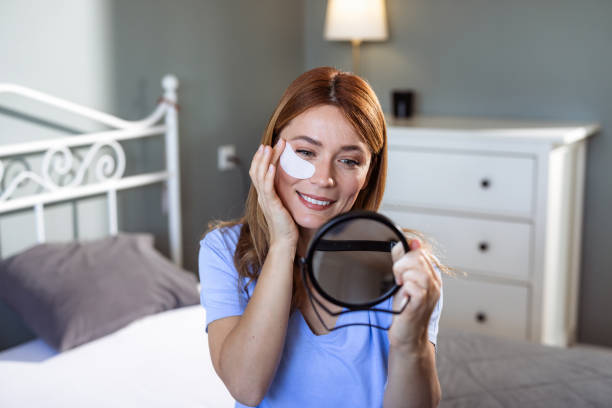 istock Smiling woman applying skincare patch in a cozy bedroom setting 2188503191