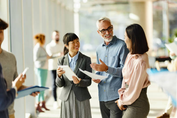 istock Happy business colleagues talking while working in a hallway. 2188503394