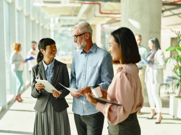 istock Happy business colleagues talking while using touchpad in the office. 2188504092