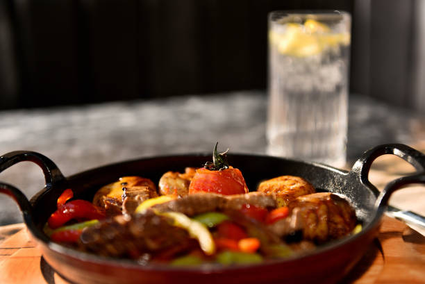 Hot bowl with potatoes vegetables and meat served with cold drink