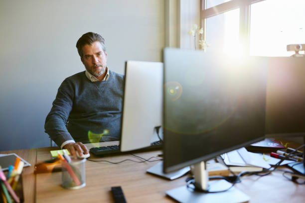 istock Mid adult businessman working on desktop PC in the office. 2188506143