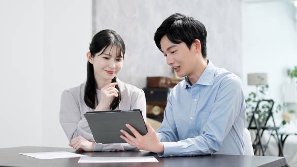 Men and women looking at documents on a tablet stock photo