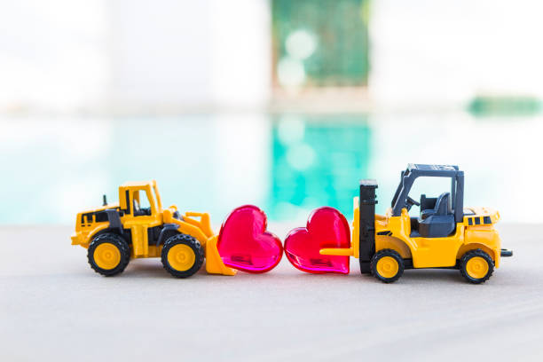 istock Forklift truck and front loader truck with red heart over blurred background 2188512320