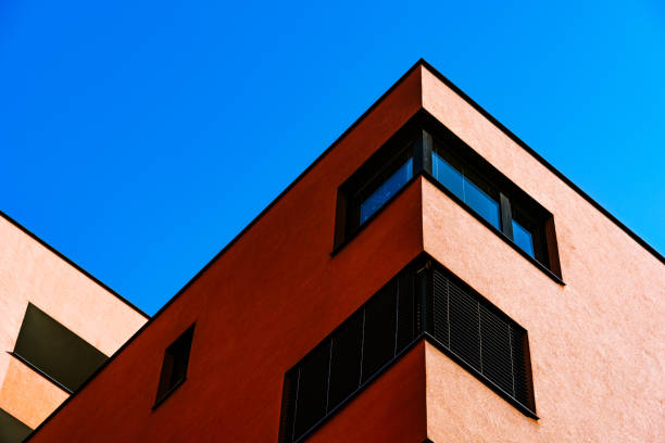 istock Vibrant Building Corner with Contrasting Red and Yellow Facade and Reflective Windows 2188513364