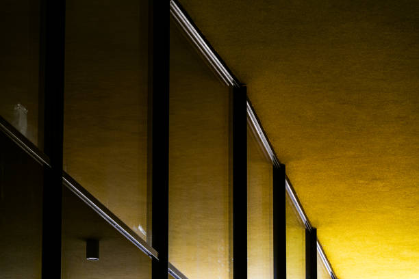 Modern Glass Building with Reflective Windows and Golden Accent Panels in Urban Setting
