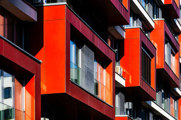 istock Modern Apartment Facade with Bold Red Panels, Glass Windows, and Playful Light and Shadow 2188513580