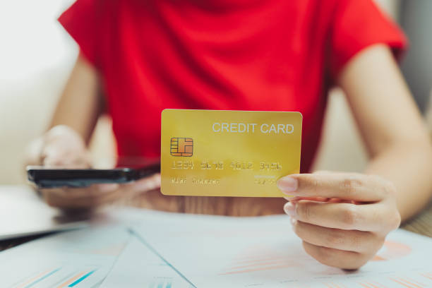 istock person holding credit card while using smartphone, surrounded by financial documents. This conveys sense of modern financial management and online transactions 2188513951