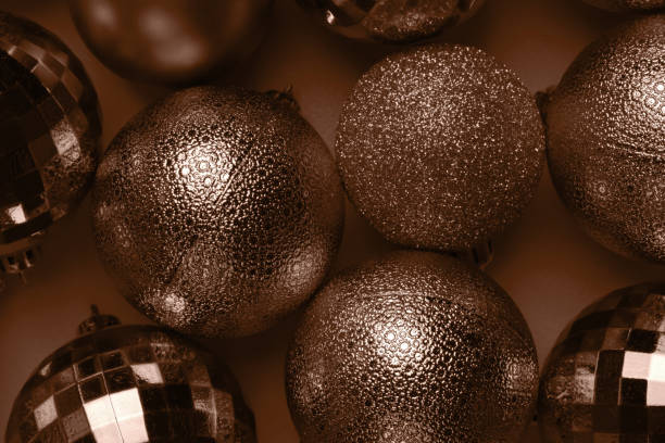 Christmas card with brown, mocha mousse glitter bauble balls on brown background. Demonstrating color, trend 2025 year