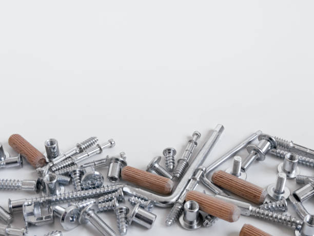 istock Assorted metal screws and wooden dowels on a white surface 2188516252