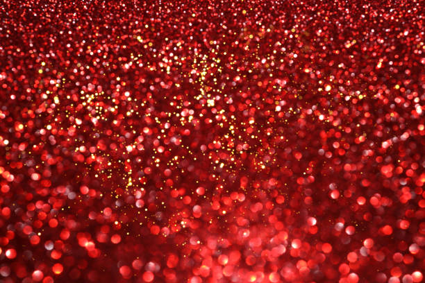 Red glitter bokeh background with sparkling light, abstract defocused texture. Holiday lights.