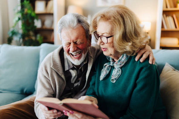 istock Senior couple reading book at home 2188517068