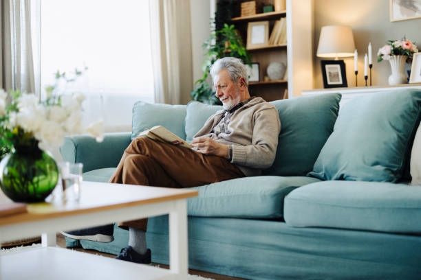 istock Senior man reading book and resting at home 2188517273