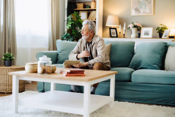 istock Senior man reading book and resting at home 2188517362
