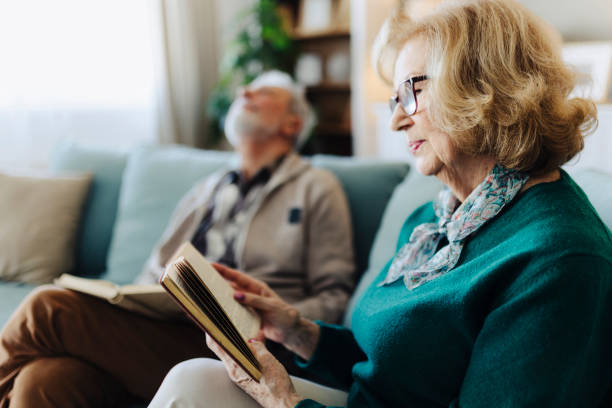 istock Senior couple reading book at home 2188517461