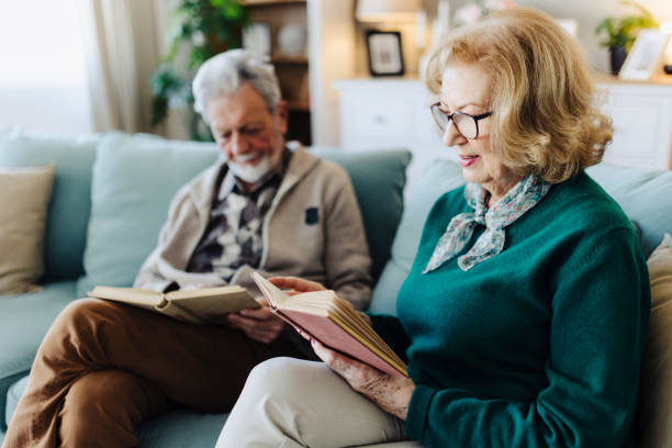 istock Senior couple reading book at home 2188517474