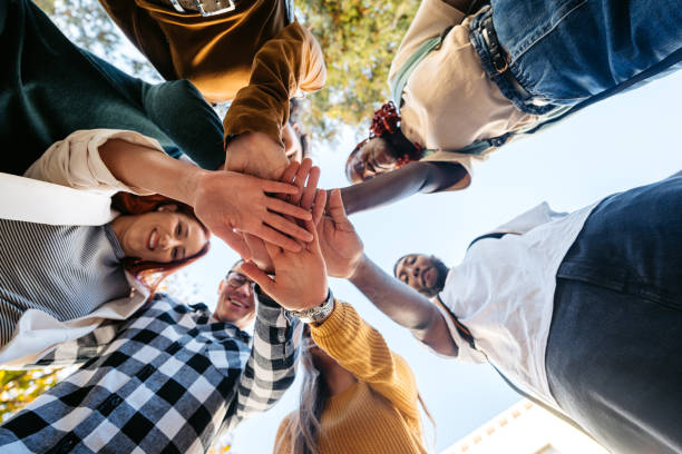 istock Group Of Students Having A Team Handshake On The University Campus 2188517497