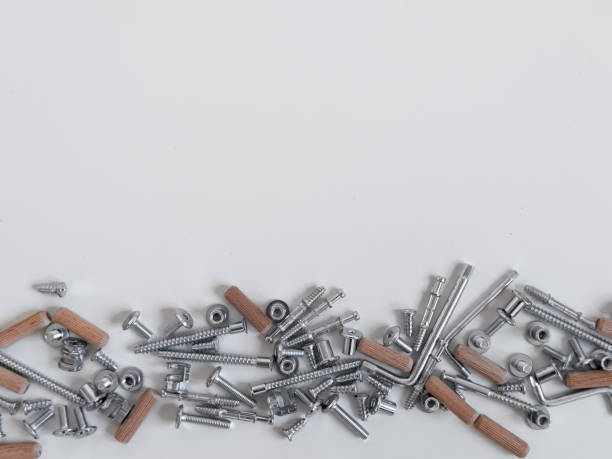 istock Assorted metal screws nuts bolts and wooden dowels on white surface 2188518154