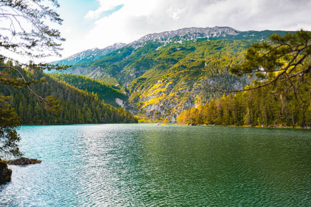 istock Scenic View of Mountain Range and Forest Reflected in Tranquil Lake Waters Under a Clear Blue Sky on a Bright Sunny Day 2188518416