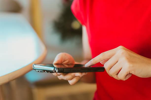 istock person in red shirt using smartphone, focused on screen, in cozy indoor setting. scene conveys sense of engagement and modern technology 2188518653