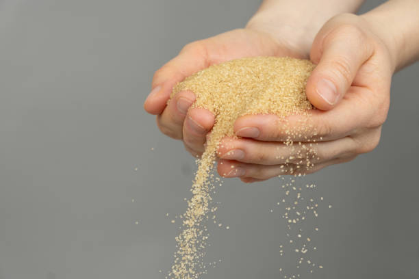 istock Hands pour crystalline cane brown unrefined healthy demerara sugar 2188520654