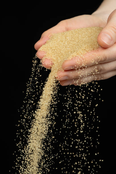 istock Hands pour crystalline cane brown unrefined healthy demerara sugar 2188520659