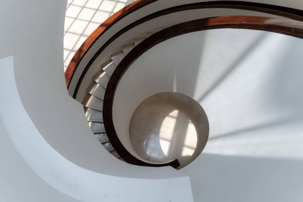 Close-up of a spiral sculpture with a blurred ocean background, showcasing the intricate texture and vibrant colors.