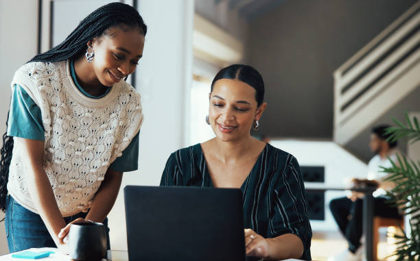 istock Two Business Women Collaborating and Sharing Ideas on Laptop 2188521535