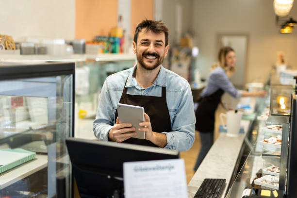 istock Smiling young  male baker at the checkout counter. 2188525728