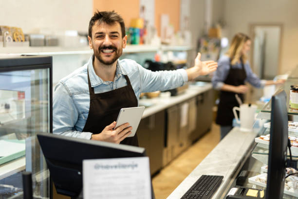 istock Smiling young  male baker at the checkout counter. 2188525830